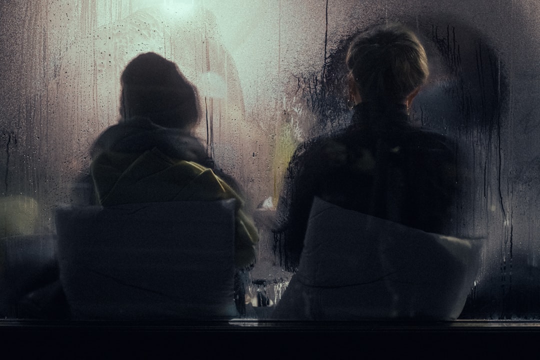 Couple sitting behind glass in winter.